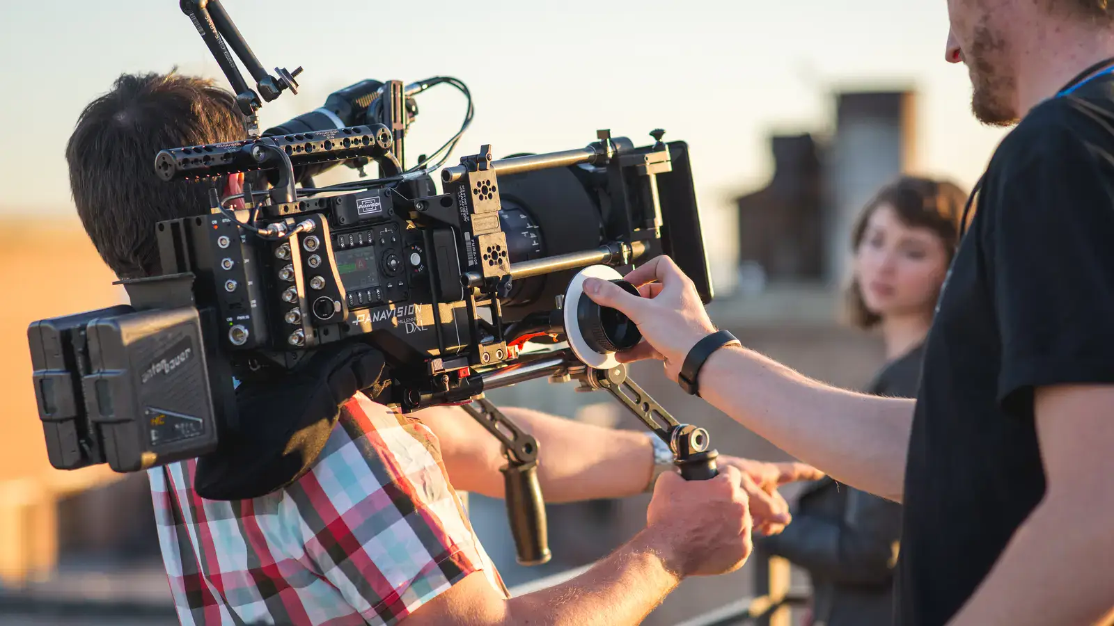 Focus puller making a precise adjustment to a Panavision cinema camera on a professional film set